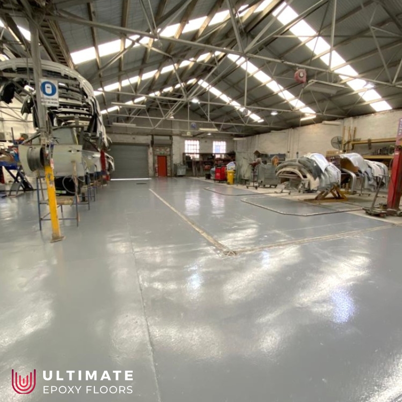 A spacious factory with a vast floor and a sturdy metal door, showcasing Factory Floor Coatings.