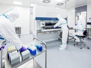 Laboratory with scientists in protective suits working on advanced equipment, featuring a highly durable epoxy floor finish.