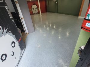 Polished concrete flooring in an indoor space with glossy finish, adding modern appeal to the room.