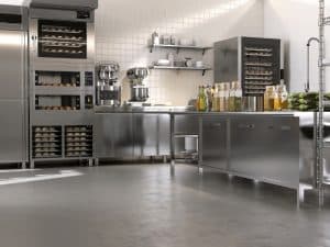 Commercial kitchen with stainless steel appliances and epoxy finish flooring for a durable, clean working environment.