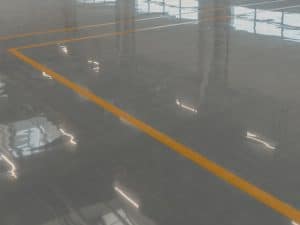 Highly reflective car park flooring with yellow lines showcasing smooth, durable epoxy finish for safety and aesthetics.