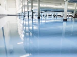 Epoxy floor showcasing impressive depth and thickness. The floor's reflective surface mirrors the overhead structures.