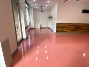 Glossy pink epoxy flooring for corridors in a modern interior, providing aesthetics and long-lasting durability.