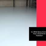 Empty warehouse with seamless white epoxy concrete floor surface ready for industrial or factory use.