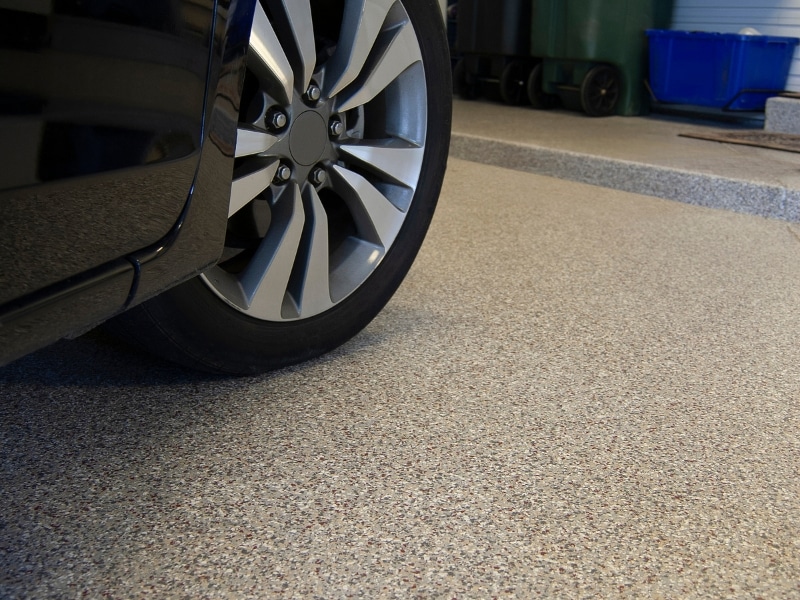 Close-up view of vehicle tire on a garage with epoxy floor.