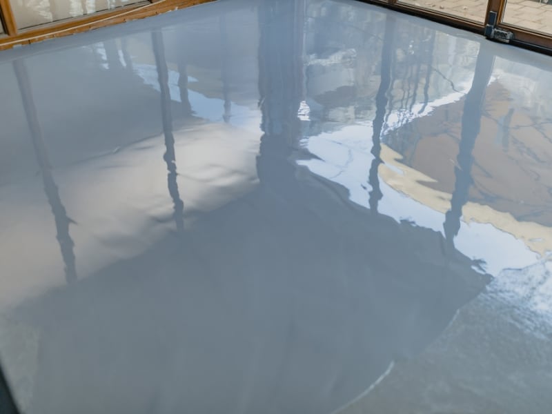 Close-up of epoxy spread showing epoxy flooring installation cost variation by surface and technique