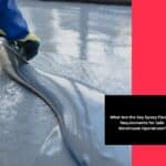 Worker spreading coating during epoxy floor application using trowel on wet surface.